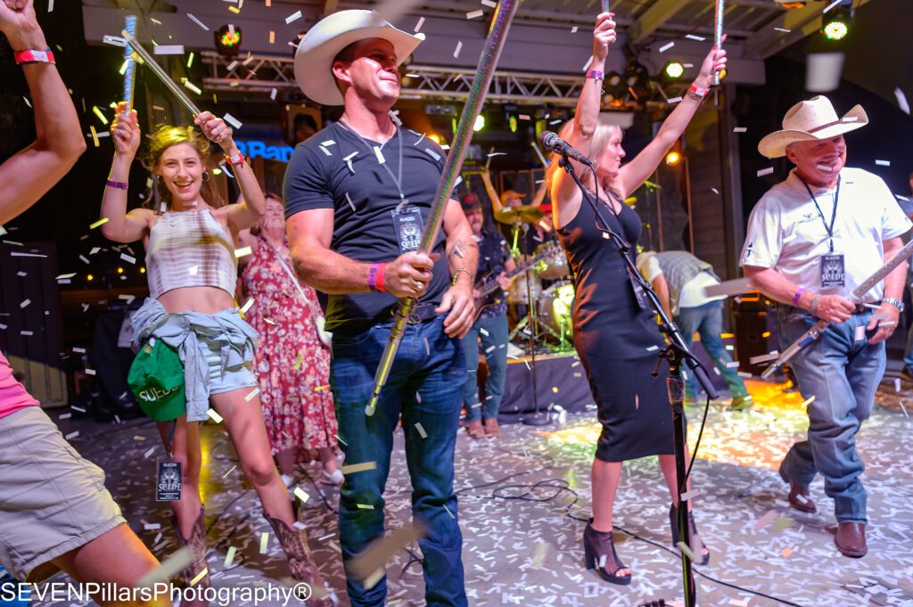 concert attendees on stage with confetti falling  