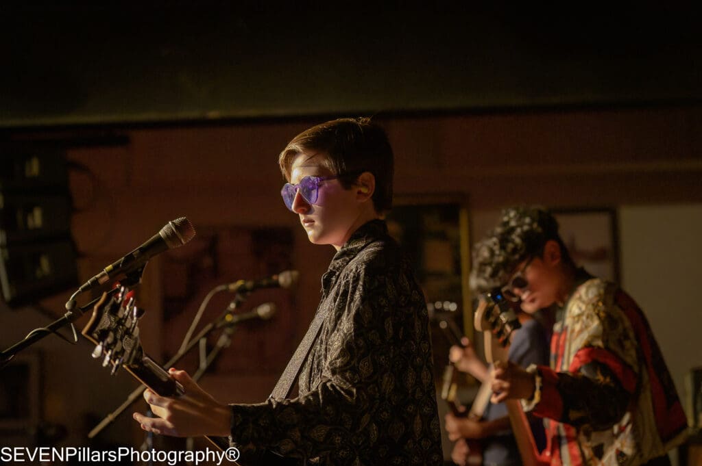 boys playing guitars during a show