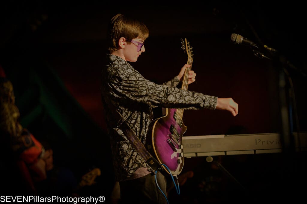 a teenage boy playing his guitar