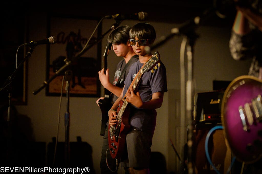 two teenage boy bassists on stage