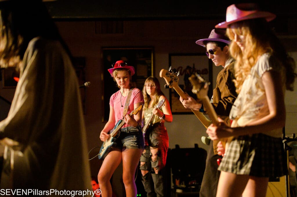 four girls and one boy in a band