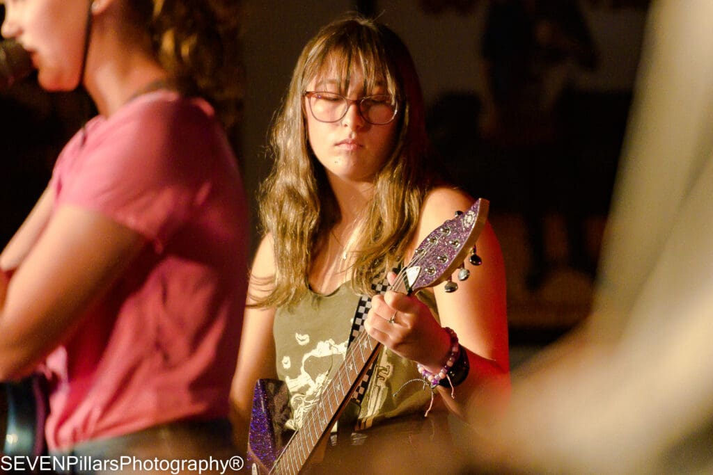 a young girl bassist wearing a pair of eyeglasses