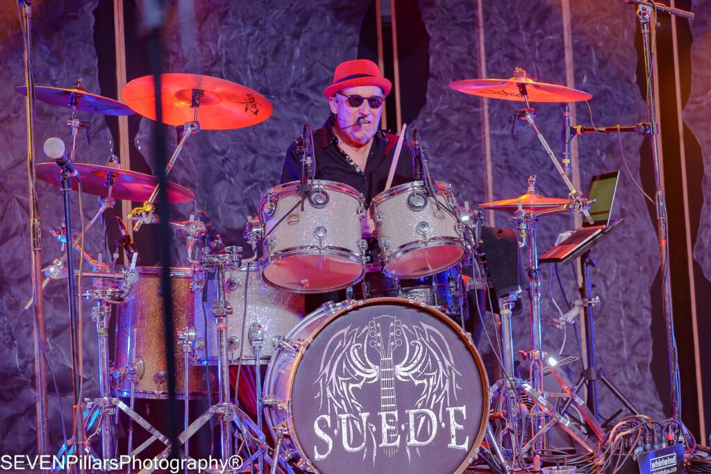 a drummer wearing a red fedora hat