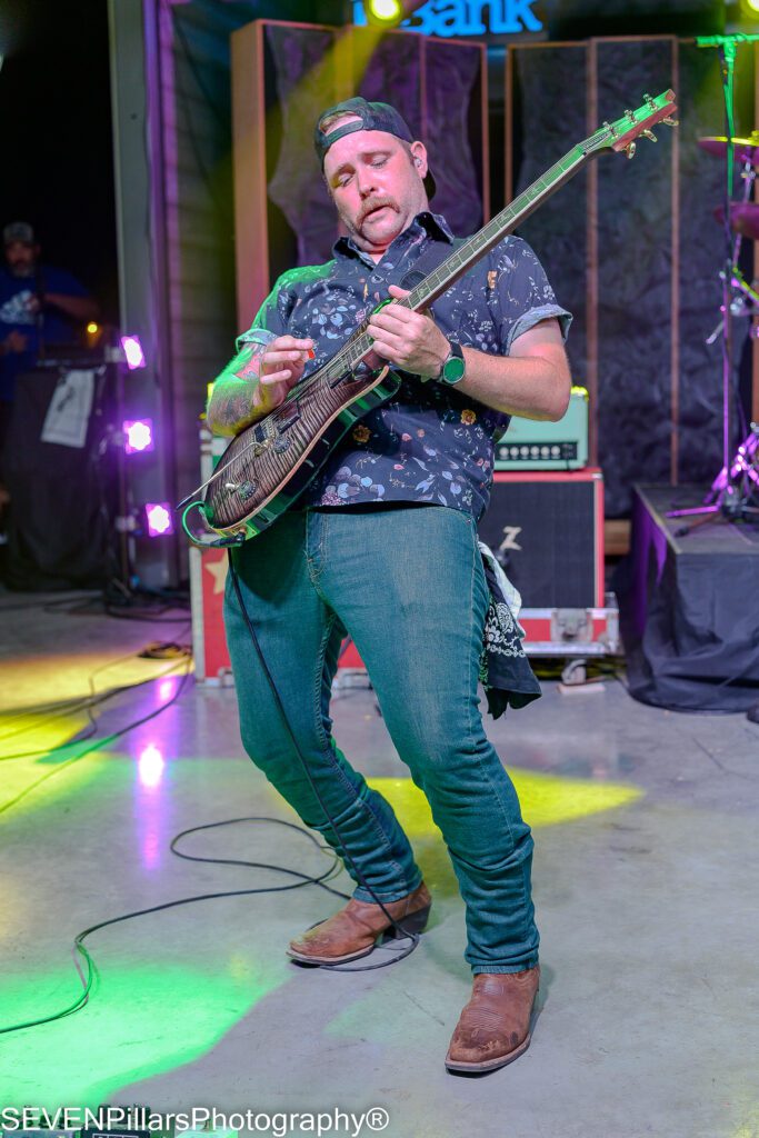 Christopher Skiles playing his guitar leaning