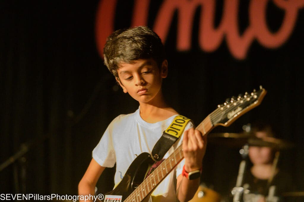 a kid playing the guitar