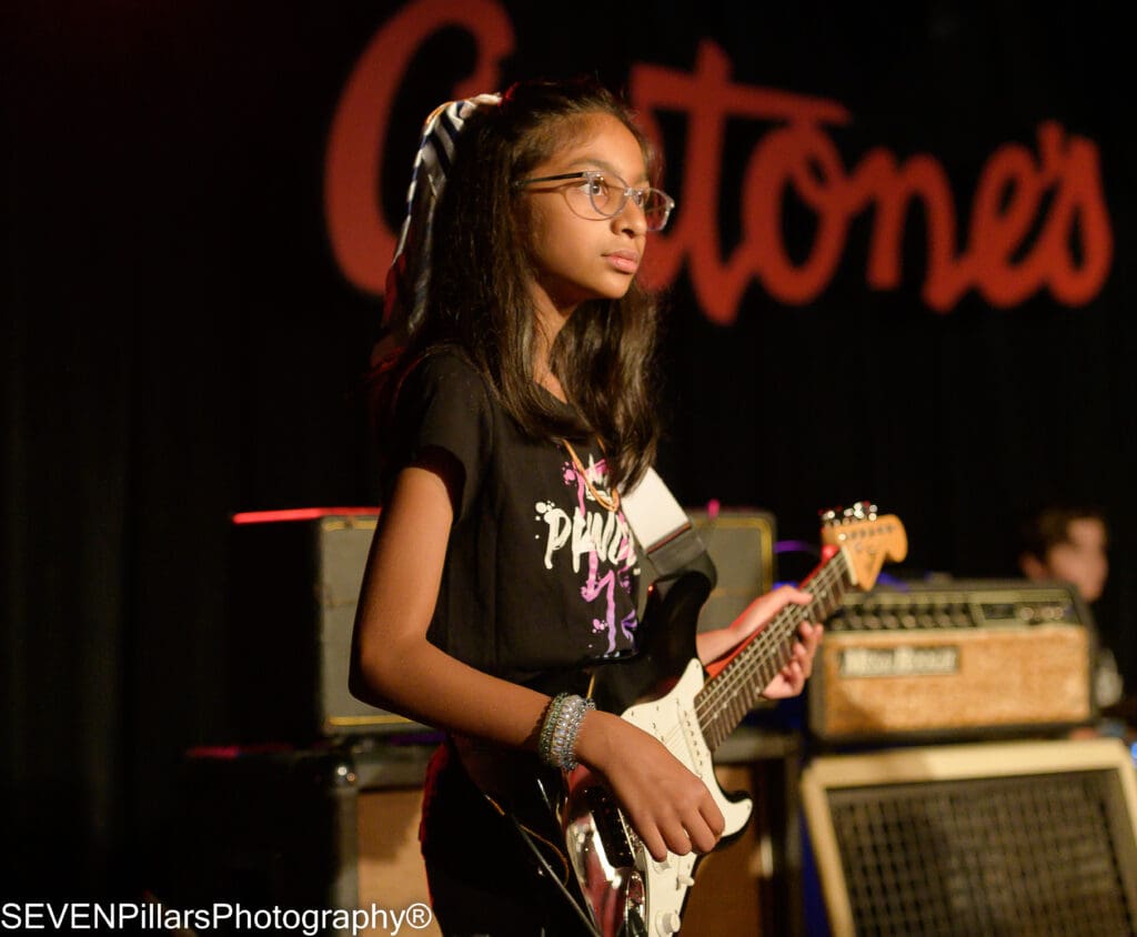 a young female bassist looking at the crowd