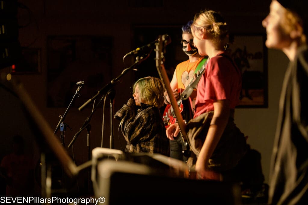 a kid member of a band holding the microphone