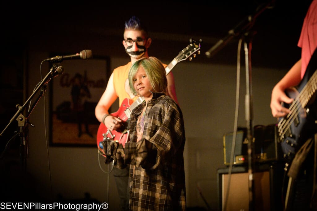 a teenage bass player with a unique mask behind the vocalist