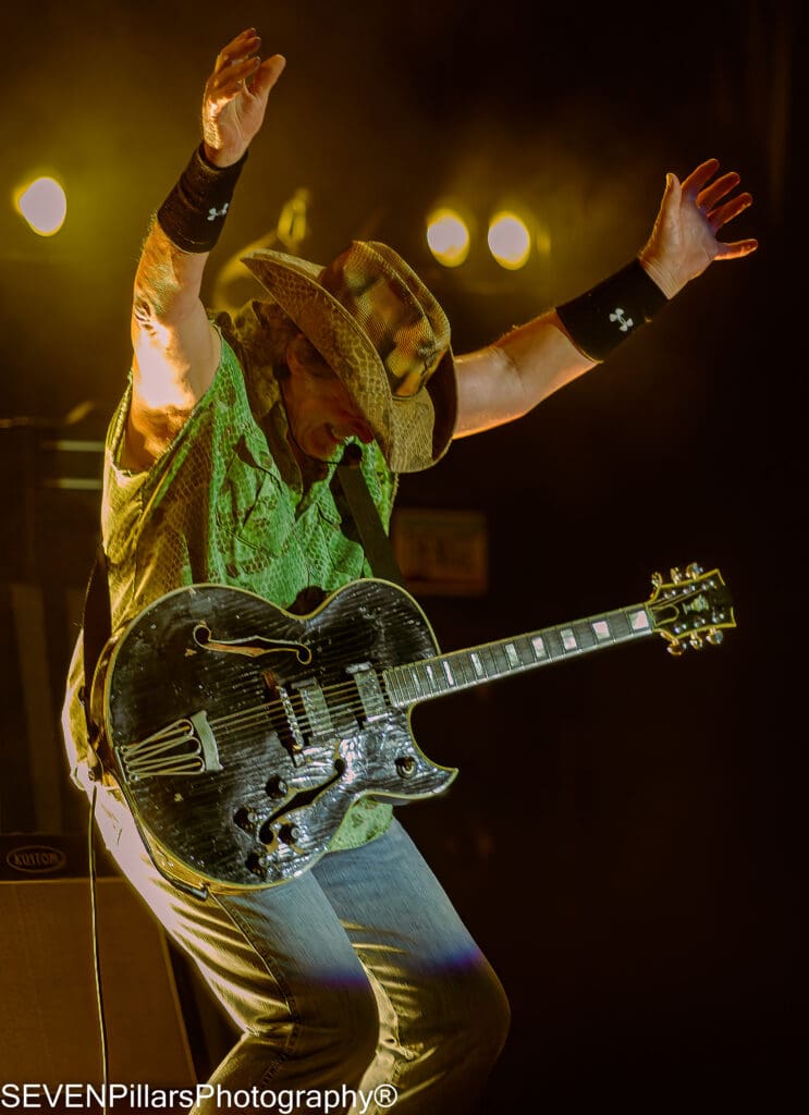 Ted Nugent smiling while raising his two hands
