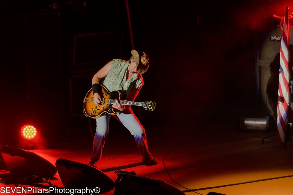 Ted Nugent wearing a cowboy hat performing on stage