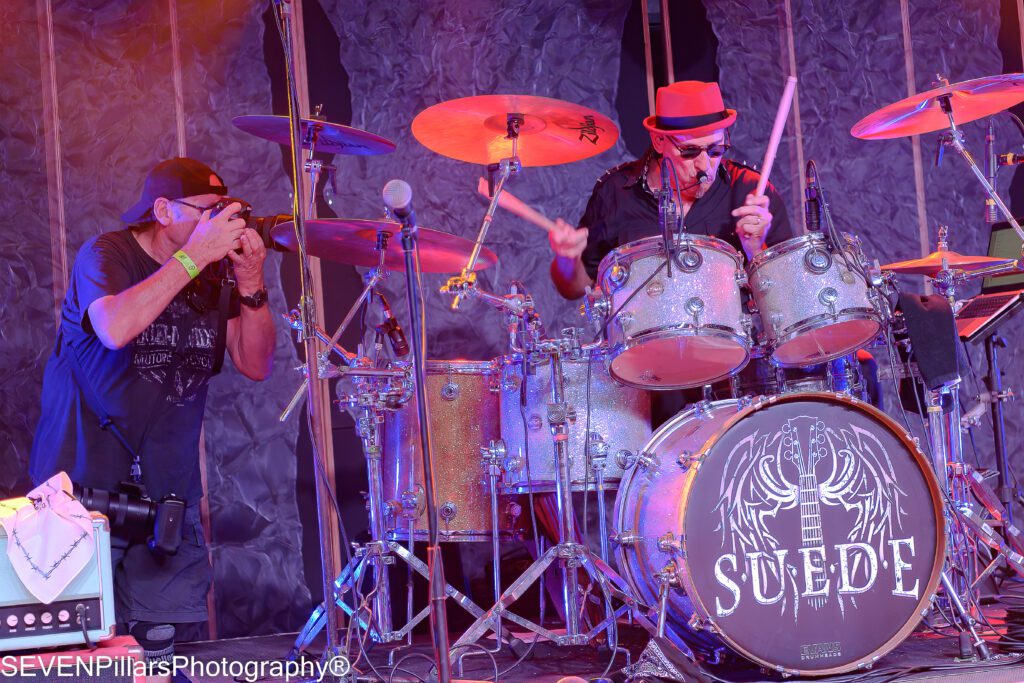 a photographer capturing a drummer while he performs