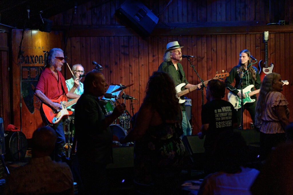 A group of people playing music in a bar.