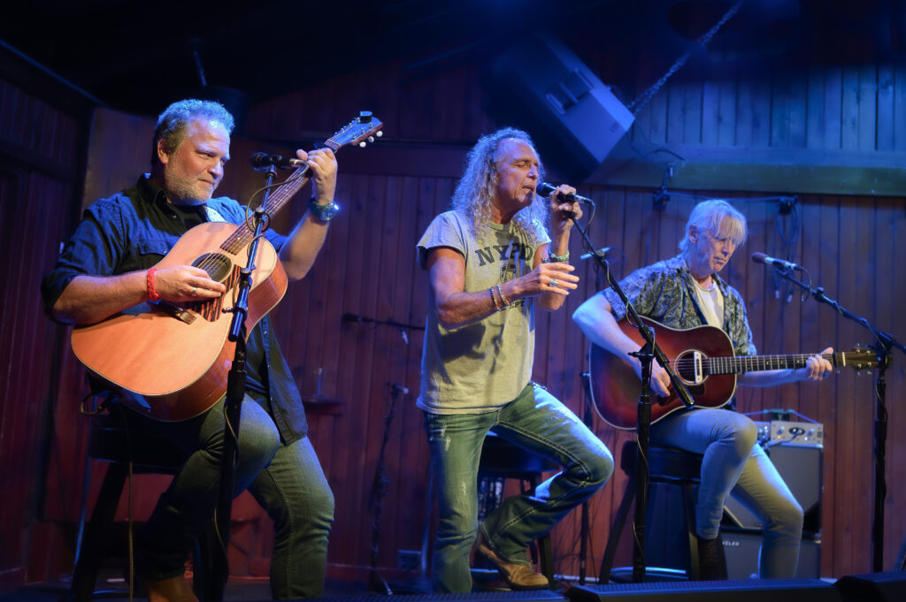 A group of people singing and playing guitars.