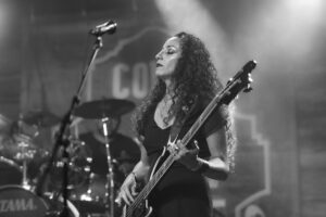 A black and white photo of a woman playing a bass.