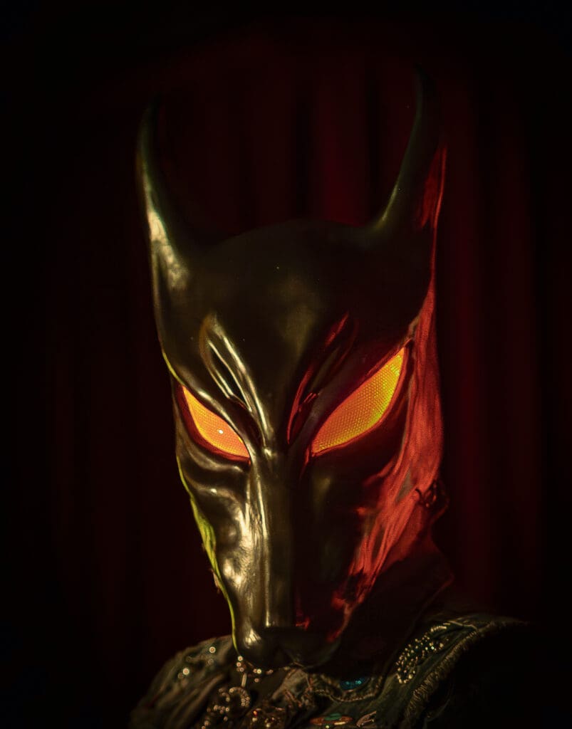 A man in a black mask with glowing eyes.